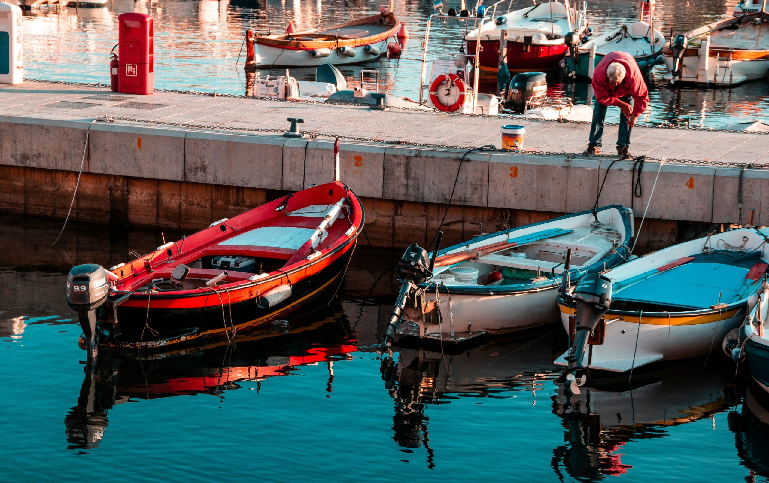 Small boats tied to a dock in a harbour.